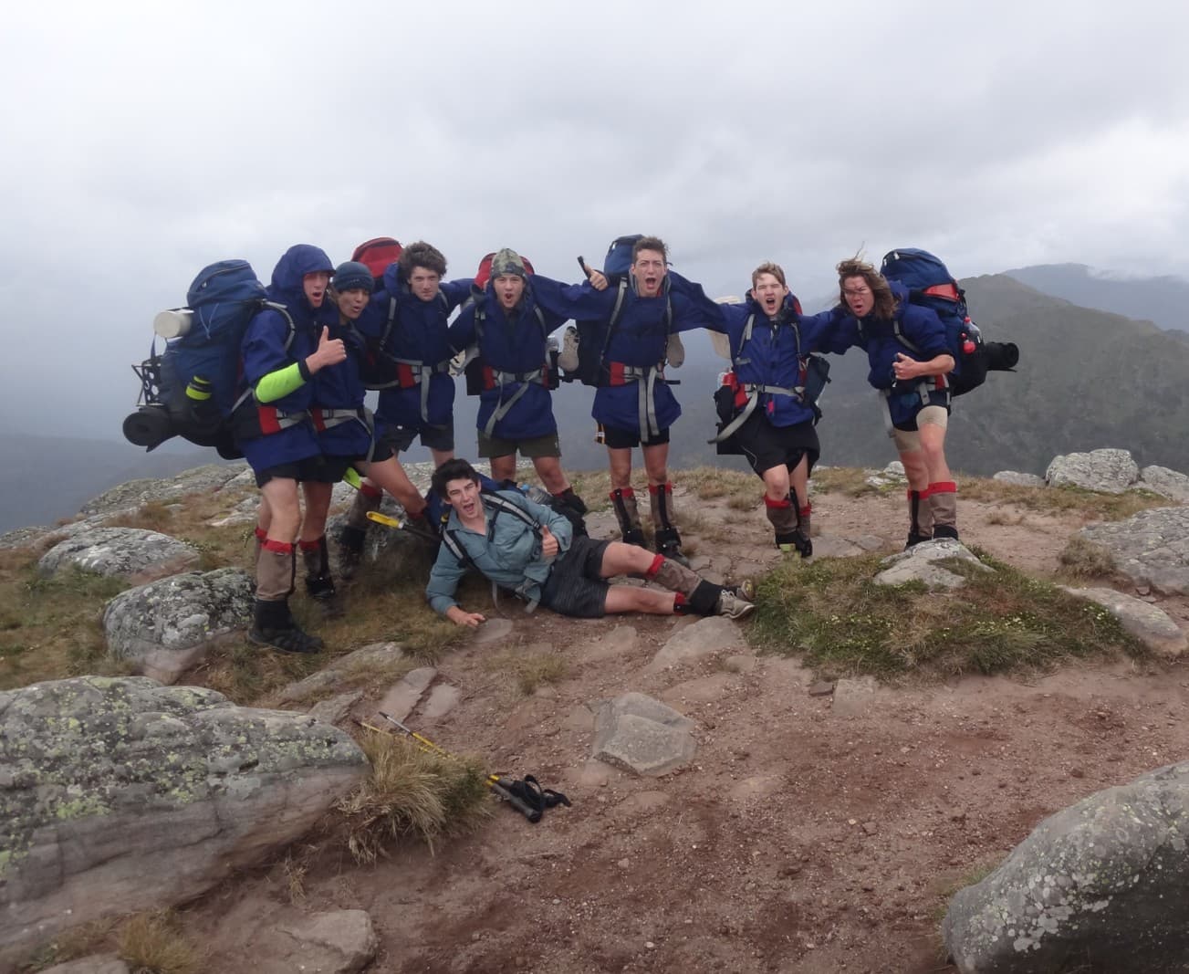 Young people celebrating on a mountain summit during a bushwalking expedition